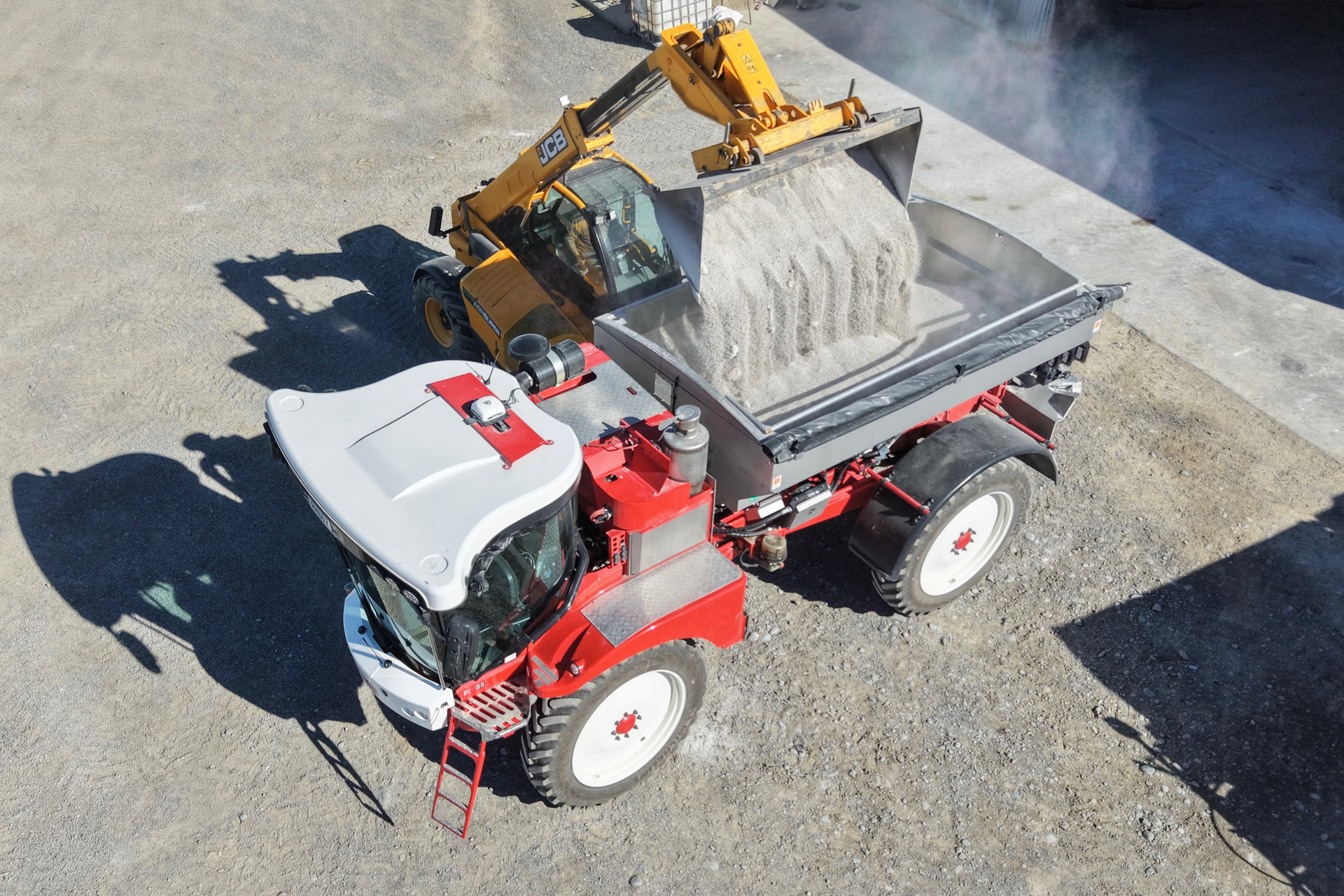 Bateman sprayer being loaded by a JCB